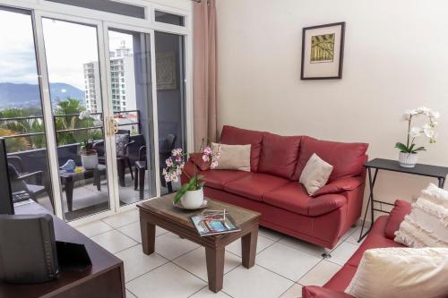 a living room with a red couch and a table at Luxury Modrn Apartment, w/amazing view, 3BR,Escalon,Exclus,Secur in San Salvador