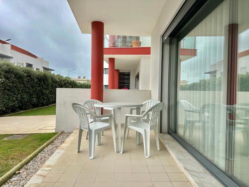 a white table and chairs on the balcony of a house at Secret Spot Baleal - Luxury Flat in Ferrel