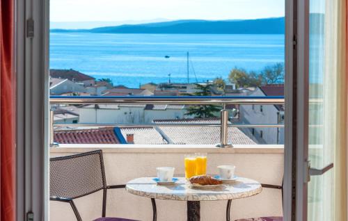 a table with two cups of orange juice on a balcony at Awesome Apartment In Baska Voda in Baška Voda