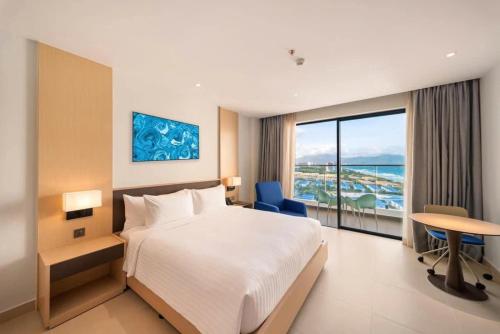 a hotel room with a bed and a desk and a window at Arena jakovi condotel in Cam Ranh International Airport