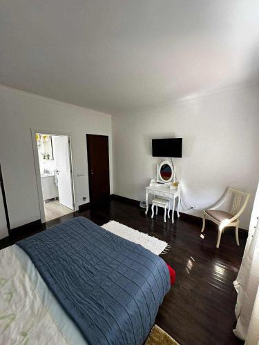 a bedroom with a bed and a table and a tv at Casa do Trevo in Salir de Porto