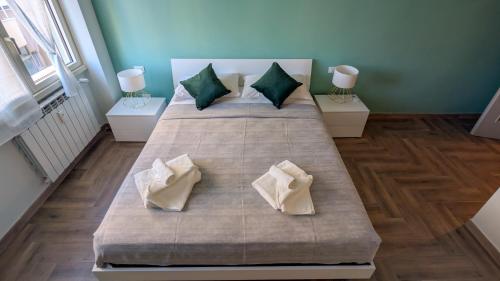a bedroom with two beds with green and white pillows at Conca D'Oro Guest House - Elisabetta in Rome