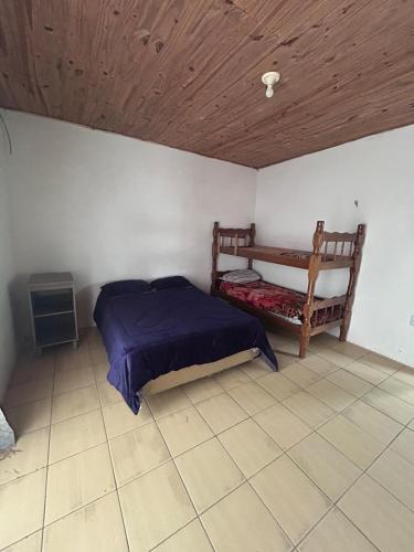 a bedroom with a bed and a wooden ceiling at Casa simples e confortavel, próx ao centro de pelotas in Pelotas