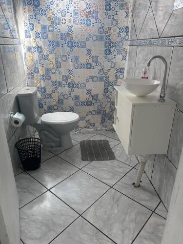 a bathroom with a toilet and a sink at Casa simples e confortavel, próx ao centro de pelotas in Pelotas