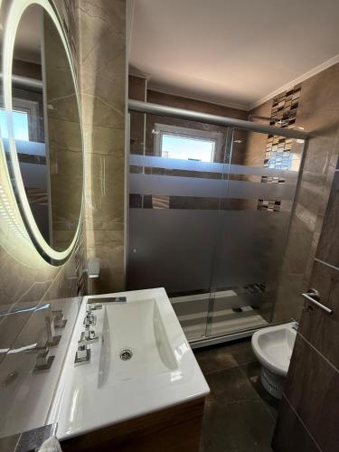 a bathroom with a sink and a toilet and a mirror at Temporario alquiler por día semana o mes in Junín