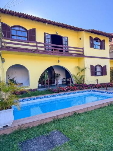 une maison avec une piscine devant dans l'établissement Pousada Casa Recanto da Serra, à Petrópolis