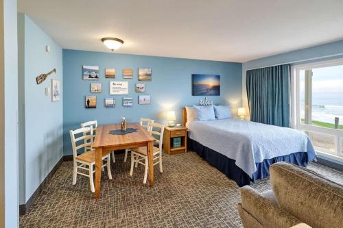 a hotel room with a bed and a table and chairs at Oceanfront Studio - Sleeps 4 - Ground Floor - Pool and Hot Tub in Lincoln City