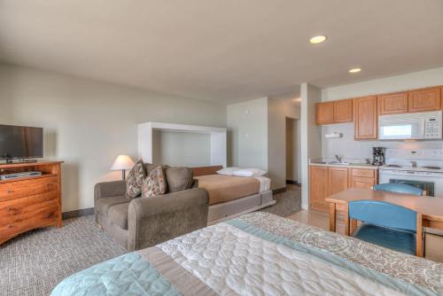 a bedroom with a couch and a bed and a kitchen at Pool and Hot Tub Ground Floor Studio - Oceanfront - Full Kitchen - Patio in Lincoln City