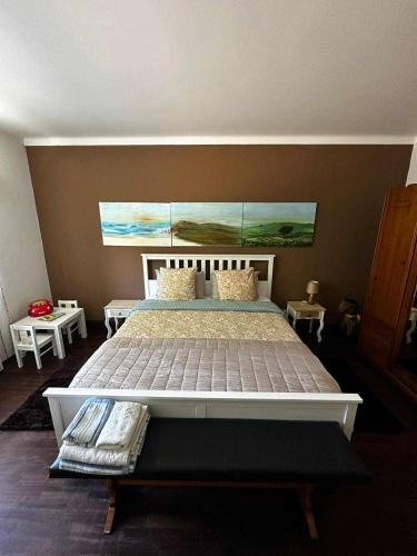 a bedroom with a large bed with a painting on the wall at Casa do Trevo in Salir de Porto