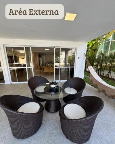 a patio with a table and chairs in a building at Carpevie Casa temporada Muro Alto in Ipojuca