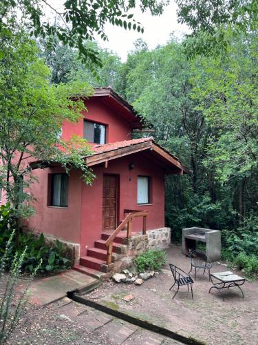 ein rotes Haus mitten im Wald in der Unterkunft Las Camellias in La Cumbre