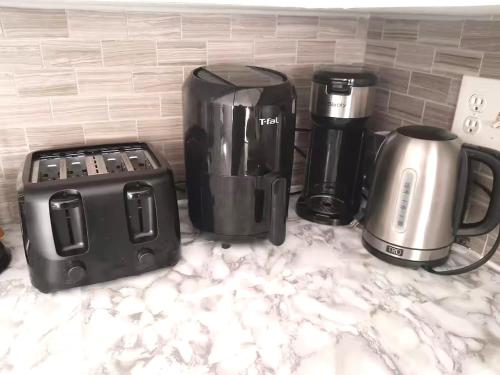a counter top with a coffee maker and appliances on it at Deluxe Room in a Cozy Apt in Saint John