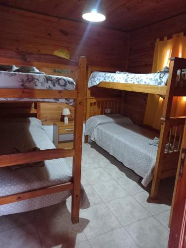 a room with three bunk beds in a cabin at Cabañas del Valle JONIVA in Termas de Río Hondo