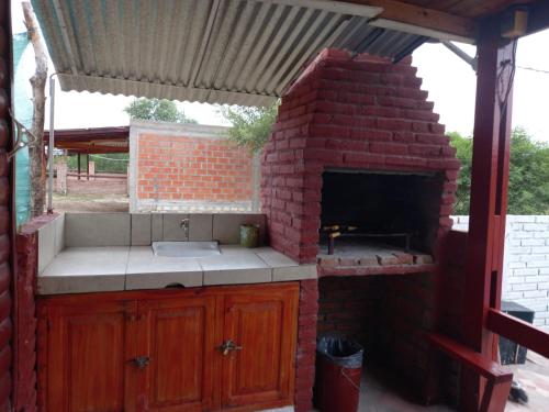 an outdoor kitchen with a brick oven with a sink at Cabañas del Valle JONIVA in Termas de Río Hondo