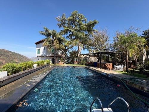a swimming pool with blue water in front of a house at Finca del Valle in Valle de Bravo