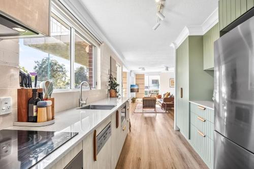 a kitchen with white counters and a large window at Hoppy's Place in Sawtell