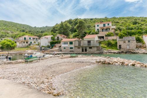 a group of houses on the shore of a body of water at Apartments by the sea Cove Donja Kruscica - Donja Krusica, Solta - 15636 in Grohote