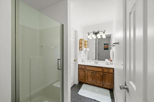 a white bathroom with a shower and a sink at Forge Chalet- Cozy Stay with Bunks, Views and Hot Tub in Pigeon Forge