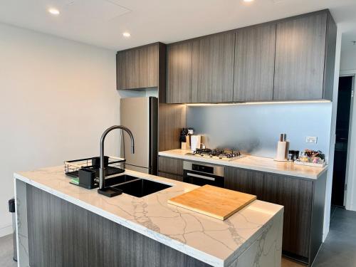 a kitchen with wooden cabinets and a counter top at Luxurious city view at Sydney Olympic Park in Sydney