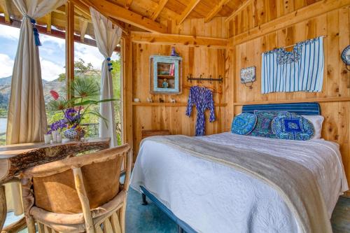 a bedroom with a bed in a wooden room at 2-story Lakefront castita, beach, kitchen, sauna in Sololá