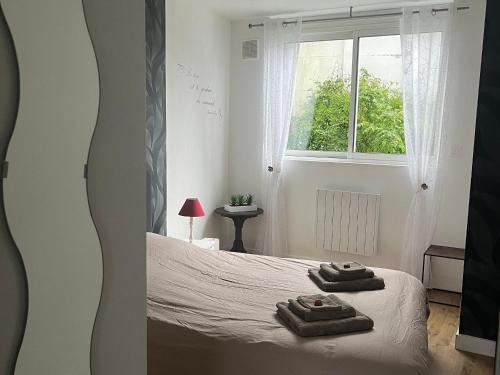 a bedroom with a bed with two towels on it at Gîte Authentique en Plein Cœur du Parc de la Brière, Proche Marais, Terrasse Sud, Tout Équipé - FR-1-306-1001 in Saint-Malo-de-Guersac