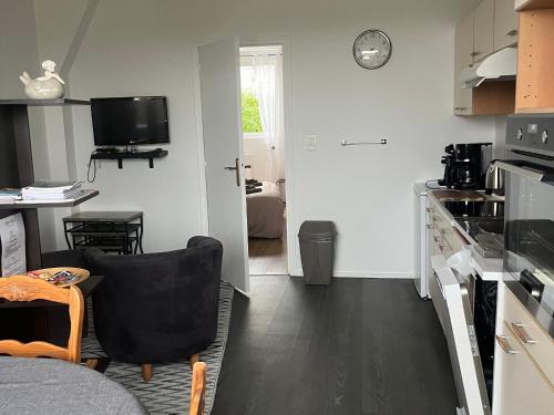 une cuisine avec une table et une chaise dans une pièce dans l'établissement Gîte Authentique en Plein Cœur du Parc de la Brière, Proche Marais, Terrasse Sud, Tout Équipé - FR-1-306-1001, à Saint-Malo-de-Guersac