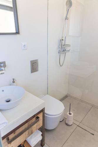 a white bathroom with a toilet and a sink at Casa Nook Sagres in Vila do Bispo