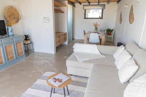 a living room with a white couch and a table at Casa Nook Sagres in Vila do Bispo