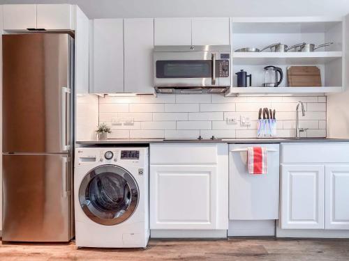 a kitchen with a refrigerator and a washing machine at River & City View Suite - The Wharf DC by Monthier in Washington, D.C.