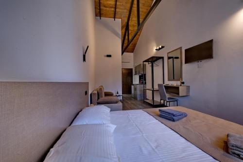 a large white bed in a room with a kitchen at 4 Lemons Luxury Studios in Ammouliani