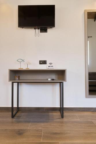 a table with a television on top of a wall at 4 Lemons Luxury Studios in Ammouliani