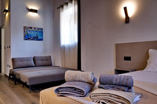 a hotel room with two beds and a couch at 4 Lemons Luxury Studios in Ammouliani