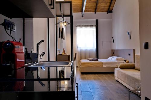 a bathroom with a sink and a bedroom with a bed at 4 Lemons Luxury Studios in Ammouliani