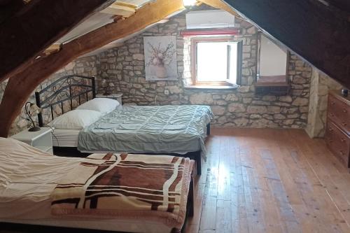 a attic room with two beds and a window at Family friendly house with a swimming pool Barban, Central Istria - Sredisnja Istra - 24471 in Barban
