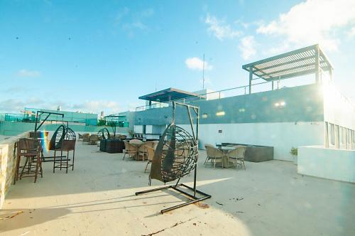 a patio with chairs and tables on a roof at Flat de frente à praia in João Pessoa