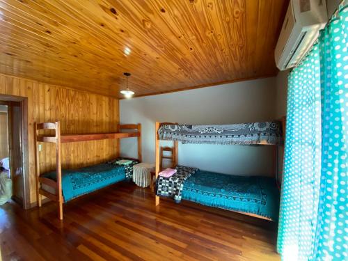 ein Zimmer mit zwei Etagenbetten und einer Holzdecke in der Unterkunft Joly in Wanda