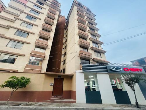 ein hohes Gebäude mit einem Schild davor in der Unterkunft Hermoso Depto in La Playa Bejarano