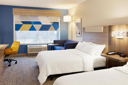 a hotel room with two beds and a desk at Holiday Inn Express Fredericksburg - Southpoint by IHG in Fredericksburg