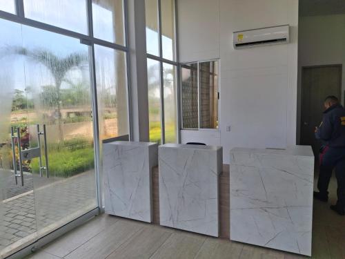 a man is standing in a room with a wall of glass at Apartamento Cartagena cerca a la playa in Cartagena de Indias
