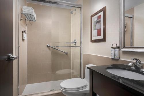 a bathroom with a shower and a toilet and a sink at Holiday Inn Express Manhattan Midtown West by IHG in New York