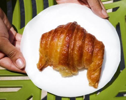a person holding a white plate with a piece of bacon at Hotel La Riviera in Santa Marta