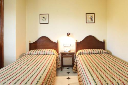 a hotel room with two beds and a table at El Cisne in Córdoba