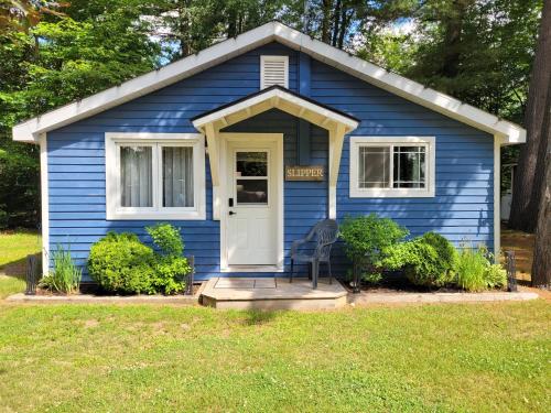 a blue house with a chair in front of it at Pine Ridge Park Campground in Pembroke