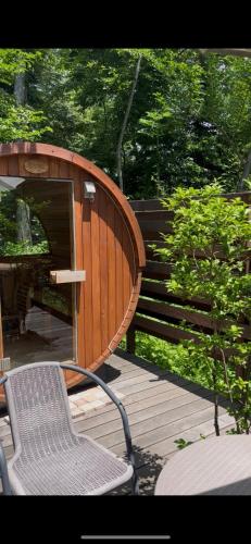 a wooden deck with a bench and a chair at Guest House Chaconne Karuizawa in Karuizawa