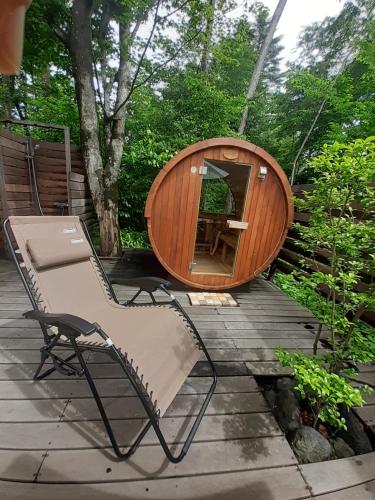 a sauna and a chair on a wooden deck at Guest House Chaconne Karuizawa in Karuizawa