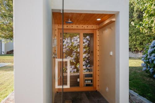 a house with a flowering door in a yard at Casa Malcata by Portus Alacer - Quinta Fonte Fria in Carreiras