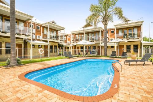 a swimming pool in front of a building at Nightcap at the Ship Inn in Busselton