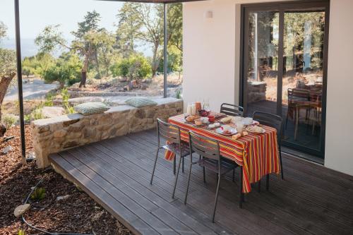 a table and chairs on a deck with a view at Casa Malcata by Portus Alacer - Quinta Fonte Fria in Carreiras