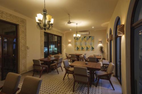a restaurant with tables and chairs and a chandelier at María Hotel Boutique ADULTS ONLY in Mérida