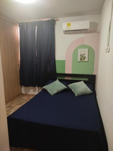 a small bedroom with a blue bed and a window at La casita de Johisfress in Cartagena de Indias
